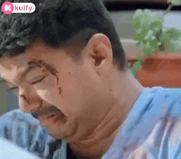 a man with a mustache and a bloody nose is crying while sitting down .