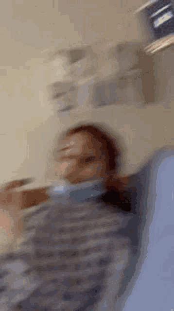 a blurry picture of a person wearing a mask and holding a thermometer .