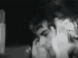 a black and white photo of a person 's face and hands