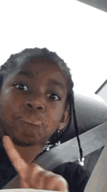 a young girl is making a funny face and giving a thumbs up .