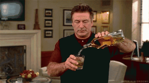 a man is pouring a glass of whiskey from a bottle ..