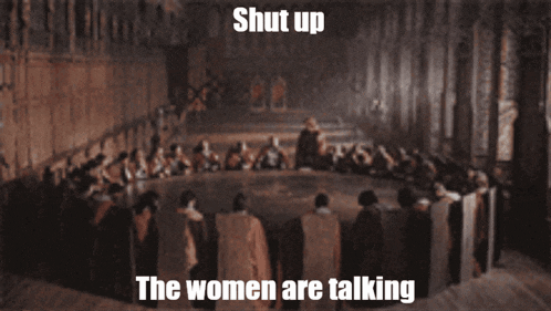 a group of people sitting around a table with the words shut up the women are talking