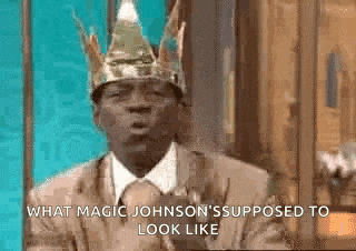 a man in a suit and tie is wearing a crown on his head .