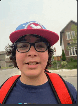 a young boy wearing a hat and glasses is smiling .