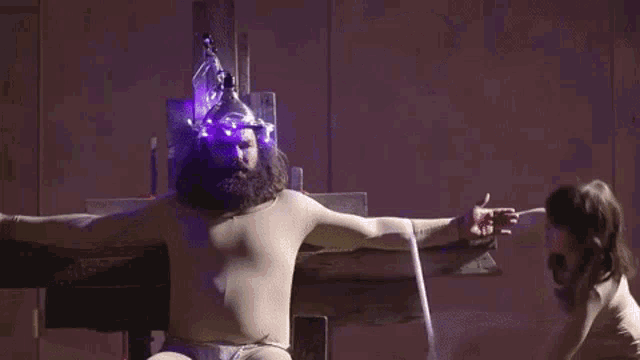 a woman is laying on a table in a dark room with a purple light on her head .