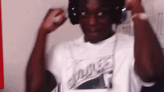 the man is wearing headphones and a white shirt .