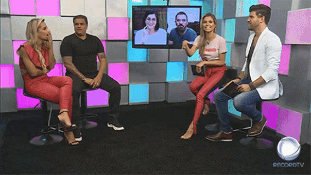 a group of people are sitting in front of a tv screen that says recordtv