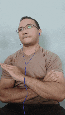 a man wearing glasses and ear buds is clapping his hands