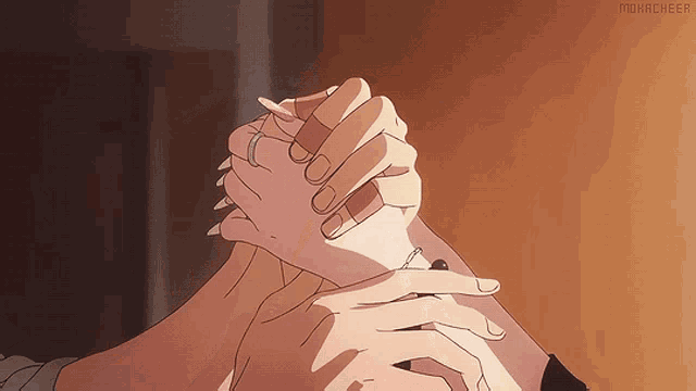 a close up of a person holding another person 's hand with the word mokacheer on the bottom right