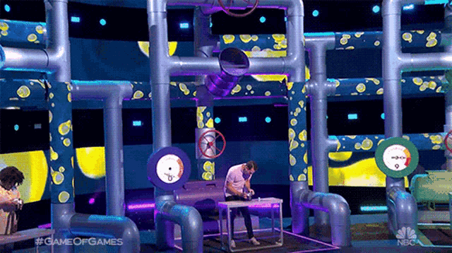 a man is playing a game of games on a stage with pipes
