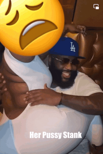 a man wearing a la hat is holding a woman 's stomach