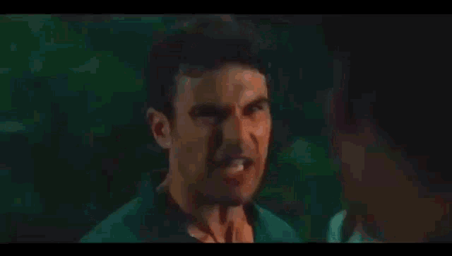a man is making a funny face while looking at a woman in a movie .
