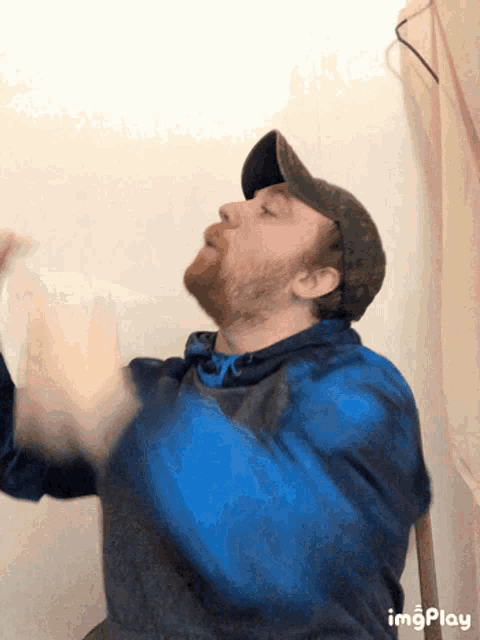 a man with a beard wearing a hat and a blue shirt is making a funny face with imgplay written below him