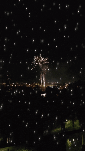 a fireworks display is being watched from a balcony at night