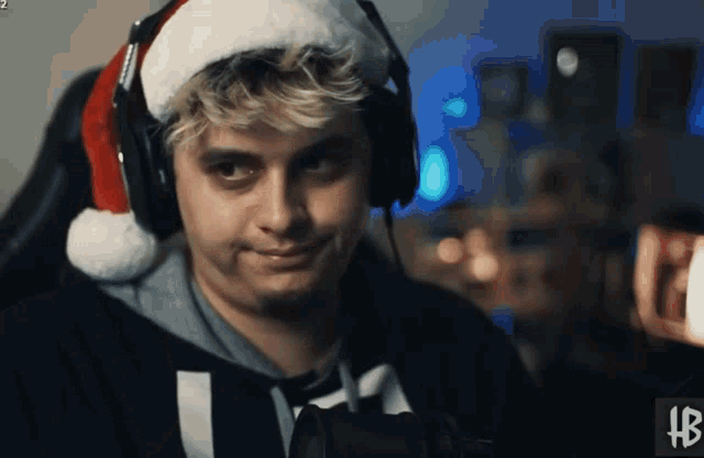 a man wearing headphones and a santa hat with the letters hb on the bottom