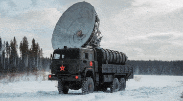 a large military truck with a red star on the side is parked in the snow