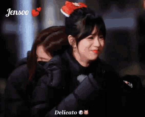 a woman in a black jacket is hugging another woman