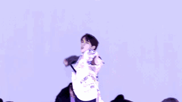 a man in a cowboy hat is dancing in front of a purple sky