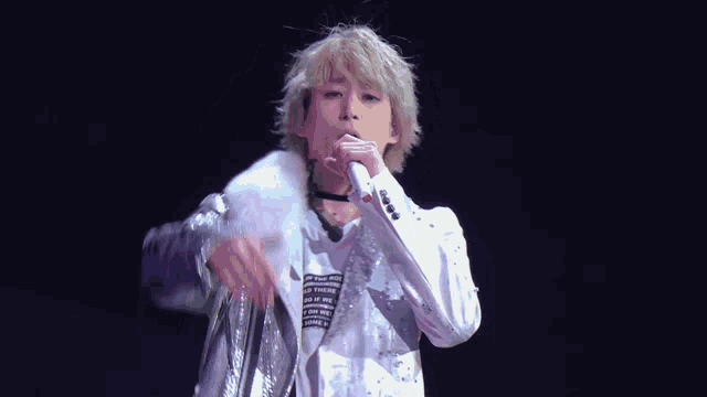 a man singing into a microphone while wearing a shirt that says " one fine day " on it