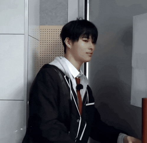 a man in a suit and tie is standing in a room