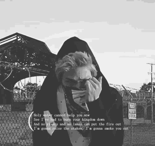 a black and white photo of a man covering his face with his hands and a quote that says holy water cannot help you now