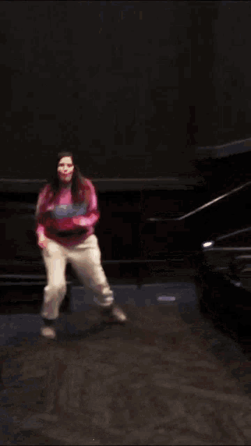 a woman wearing a pink sweater that says boys on it