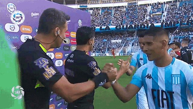 a soccer player wearing a fiat shirt shakes hands with another player