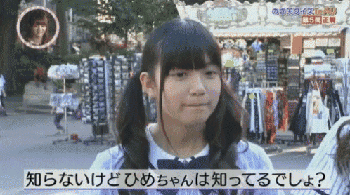a girl is standing in front of a store with foreign writing