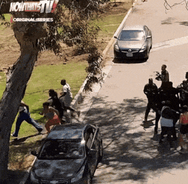 a group of people are running down a street in front of a now thats tv logo