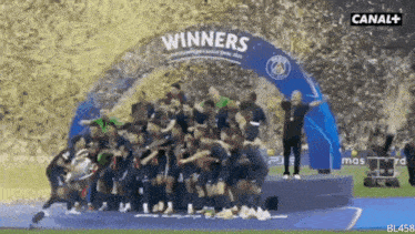 a group of soccer players are standing under a banner that says " winners "