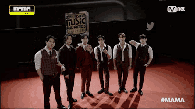 a group of men are standing in front of a sign that says mama asian music awards