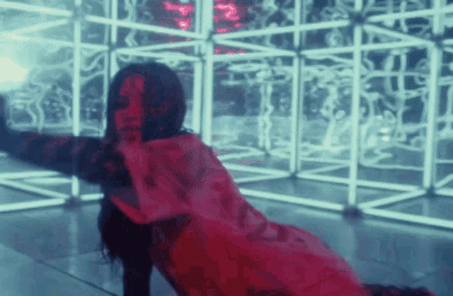 a woman in a red dress is dancing in a room with a lot of lights