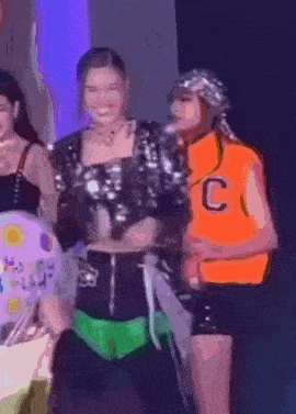a woman in an orange vest with the letter c on it stands next to another woman .