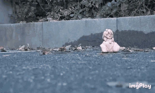 a gif of a statue laying on the ground with the words imgplay at the bottom right