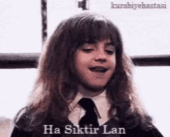 hermione granger from harry potter is wearing a black tie and a school uniform .