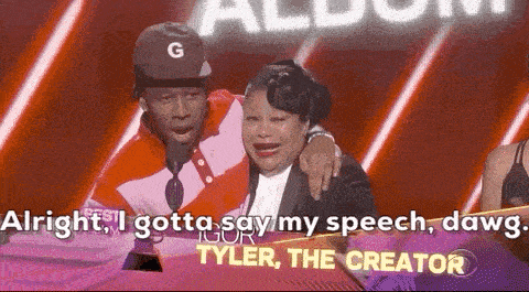 a man and a woman are sitting next to each other on a stage and the woman is crying .