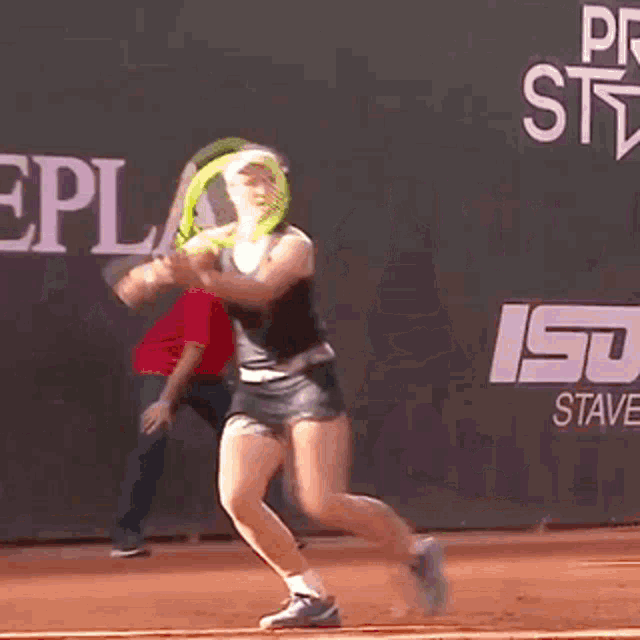 a woman playing tennis in front of a banner that says port repl trophy