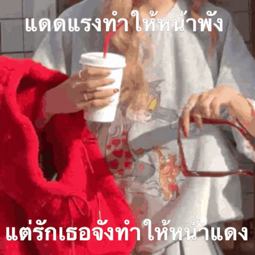 a woman in a tom and jerry shirt is drinking from a cup with a straw