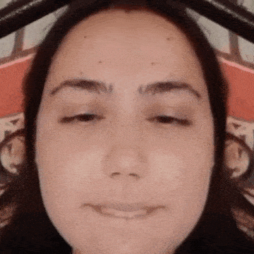 a woman is making a funny face with her eyes closed .