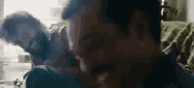 a man and a woman are sitting on a couch and talking to each other .