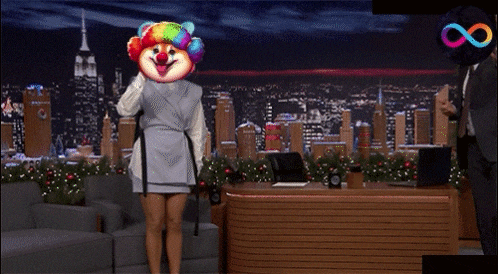 a woman with a clown mask on her head stands in front of a man in a suit