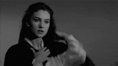 a black and white photo of a woman covering her chest with her hand