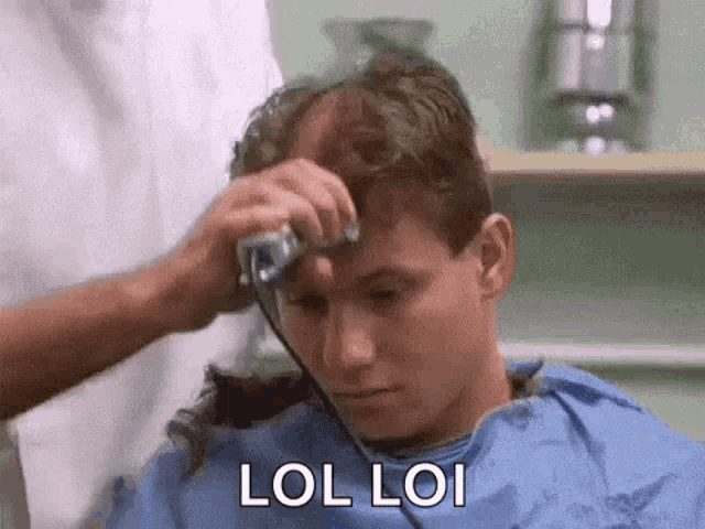 a man is getting his hair cut by a barber in a barbershop .