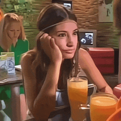 a woman wearing a headband sits at a table with a glass of orange juice