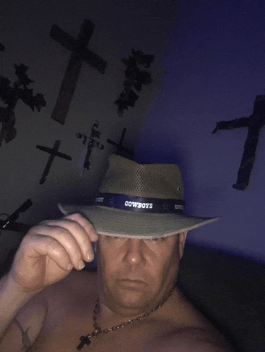 a shirtless man wearing a cowboys hat
