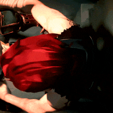 a person with red hair is laying on their back with their arms outstretched