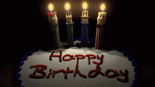 four candles with faces on them are lit up in front of a sign that says happy birthday