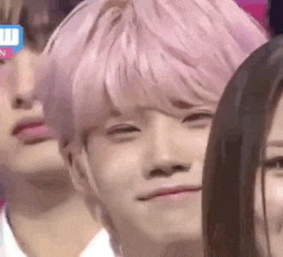 a group of people with pink hair are sitting next to each other and making funny faces .