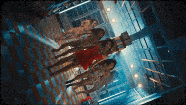a group of women in dresses are dancing in a dark room