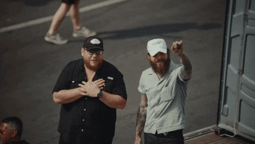 two men are standing next to each other and one has a white hat that says ' i love you ' on it